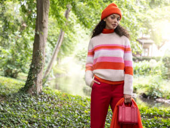 Žena nosí pruhovaný kašmírový svetr.