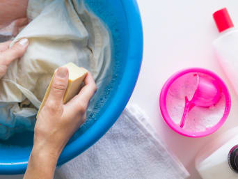 Žena si pomáhá při praní prádla žlučovým mýdlem.