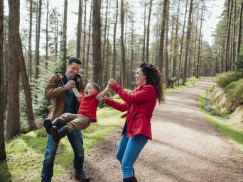 Spiele Wald – Eltern spielen mit ihrem Kind im Wald.