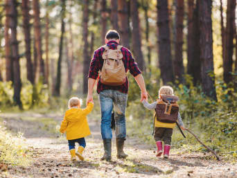 Verhalten im Wald – Vater geht mit seinen Kindern durch den Wald.