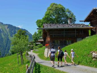 Hüttenwanderung Familie – Familie läuft gemeinsam zu einer Hütte.