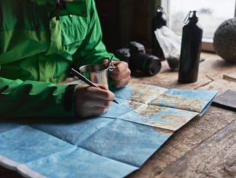 Consigli trekking: un escursionista pianifica l’itinerario dell’escursione con l’aiuto di una mappa.
