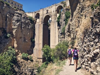Grandes rutas a pie por España: dos excursionistas caminan por un sendero en la localidad de Ronda.