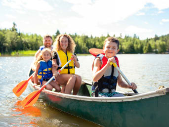 Kanutour: Eine Familie unternimmt gemeinsam eine Kanutour auf einem See.