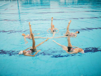 Nuoto sincronizzato: nuotatrici si esercitano nel nuoto artistico e formano una stella.