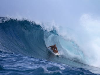 Surfen – Jonge vrouw surft in de tunnel van een golf