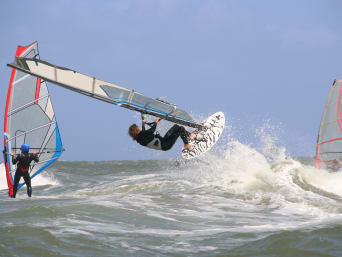 Attrezzatura windsurf: alcuni surfisti eseguono alcune evoluzioni o trick con la loro tavola da windsurf.