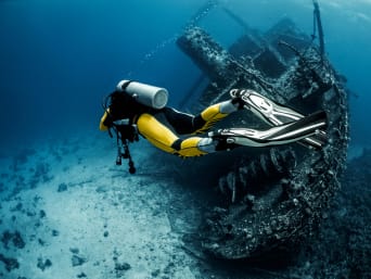 Buceo para principiantes: un buceador profesional explora los restos de un naufragio.