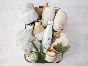 Detalles de Navidad hechos a mano: cesta con distintos regalos para pasar un invierno acogedor en casa.