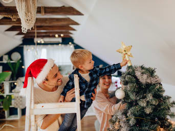 Weihnachtsbräuche - Familie schmückt gemeinsam den Weihnachtsbaum.