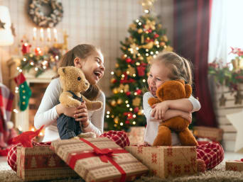 Bescherung: Baby spielt unterm Weihnachtsbaum.