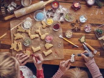 Baking Christmas biscuits with children– children decorating Christmas themed biscuits. 