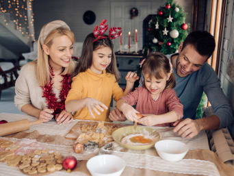 Recetas de galletas navideñas sencillas para niños: una familia prepara la masa de las galletas juntos.