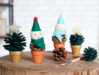 Christmas crafts: Homemade Christmas trees and Christmas elves on painted and pasted pinecones.