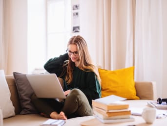 Vrouw doet persoonlijke opleiding thuis op de computer.