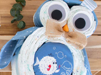 Diferentes regalos de pañales con accesorios para bebés y decorados para niños.