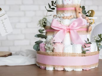 Un gâteau de couches décoré avec des nuances de rose pour une fille.