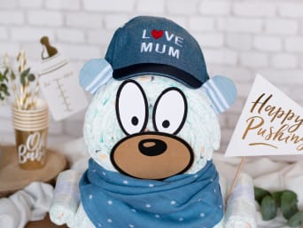 Close-up of a teddy bear diaper cake in shades of blue.