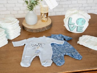 Decorate the inner belly of the owl diaper cake with a baby bodysuit.