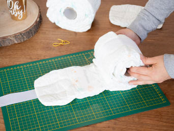 Homemade nappy cake - making wheels from nappies.