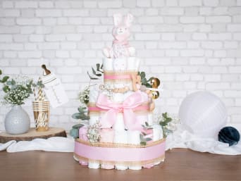 Un gâteau de couche décoré et garni avec différents articles pour bébé.