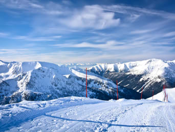 Najlepsze polskie stoki narciarskie: panorama ośnieżonych grani widoczna z trasy zjazdowej na Kasprowym Wierchu.