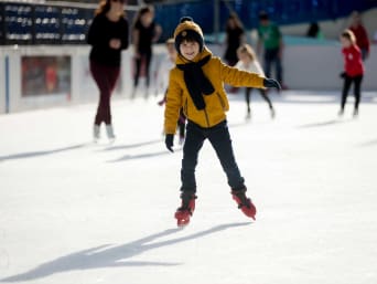 Eiskunstlauf für Kinder: Junge läuft auf einer Eisbahn Schlittschuh.
