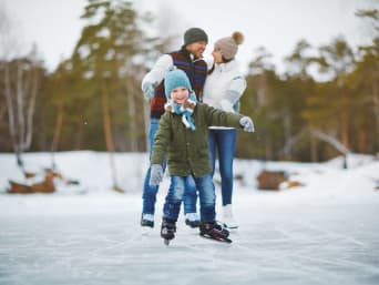 Eislaufen: Familie läuft Schlittschuh auf einem zugefrorenen See.