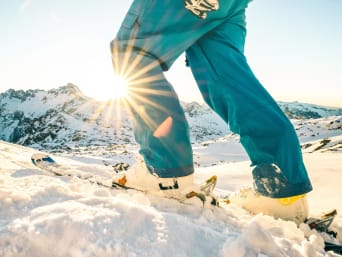 Günstige Skigebiete Österreich: Skifahrer steigt einen Hang hinauf.