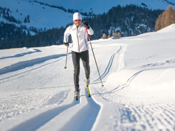 Die schönsten Langlaufgebiete in Österreich: Langläufer fährt durch Schnee.