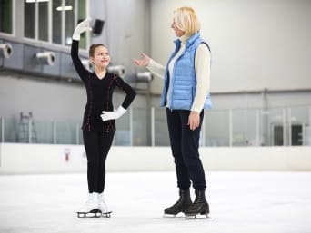Patinaje artístico sobre hielo para niños: una profesora de patinaje enseña movimientos a una alumna.