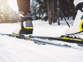 Où faire du ski de fond en France : chaussures et skis d’une personne pratiquant le ski nordique. 