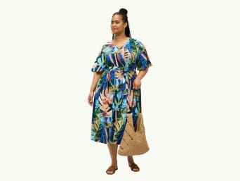 Vrouw in een kleurrijke outfit: jurken met wijde mouwen verhullen vollere bovenarmen. Vrouw in een kleurrijke outfit: jurken met wijde mouwen verhullen vollere bovenarmen.