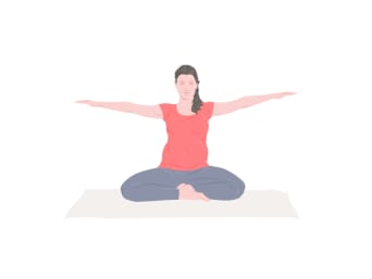 Yoga e gravidanza – Una donna seduta con le gambe incrociate e le braccia tese.