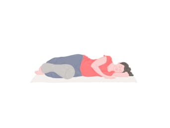 Posturas de yoga para el embarazo: una mujer embarazada realiza la savasana de lado.