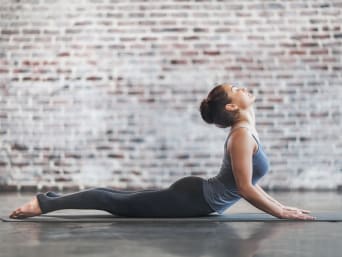 Anusara yoga: una mujer hace la postura de la cobra.
