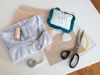 Tools needed for sewing DIY cloths - fabric, scissors, thread, tape measure and a ruler.
