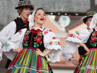 Zespół pieśni i tańca: tancerze w tradycyjnych strojach łowickich na festiwalu folkloru.