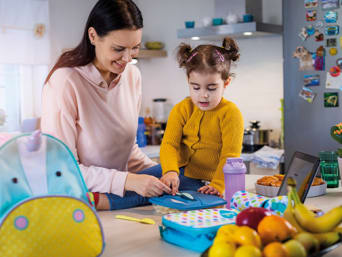 Kindergartentäschli – Mutter und Tochter packen zusammen den Kindergartenrucksack.