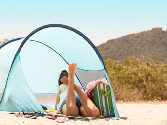 Strandmuschel – Eine Strandmuschel mit Seitenwänden bietet einen Windschutz am Strand