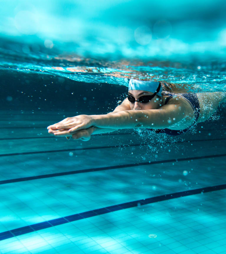 Pływanie – pływaczka nurkuje w wodzie.
