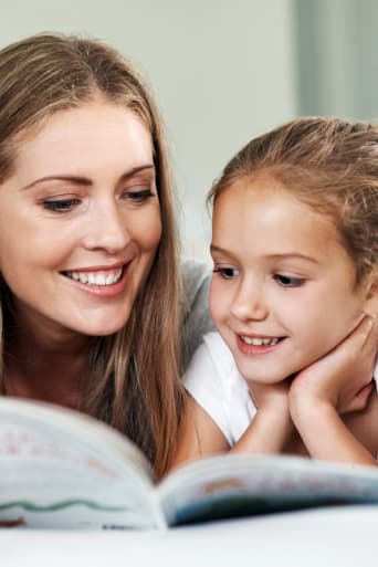 Gids: leren lezen – moeder en dochter lezen samen een boek. 