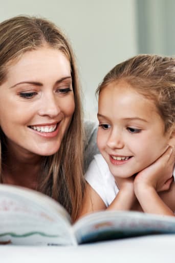Ratgeber Lesen lernen – Mutter und Tochter lesen ein Buch zusammen.