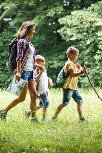 Guida vivere la natura con i bambini –una mamma con i figli durante una passeggiata nel bosco.
