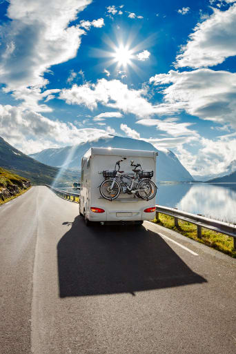 Ratgeber Camping – Wohnmobil fährt durch eine Berglandschaft.