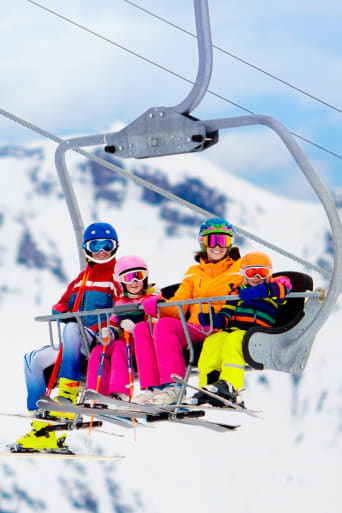 Ratgeber Winterurlaub – Familie fährt mit dem Ski-Lift.