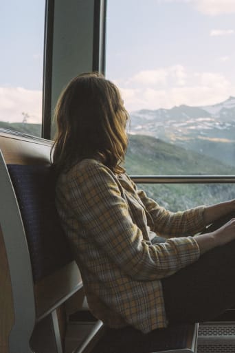 Gids voor duurzaam reizen - Jonge vrouw die met de trein reist.