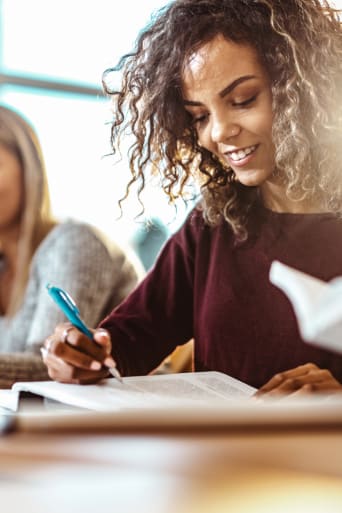 Ratgeber Studienwahl – Studentin lernt gemeinsam mit anderen Studierenden.