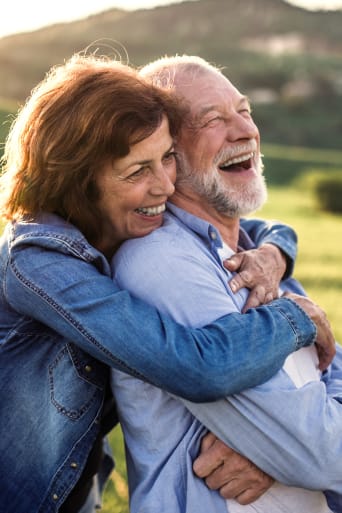 Seniorengids actief op leeftijd – vrouw omarmt haar man.