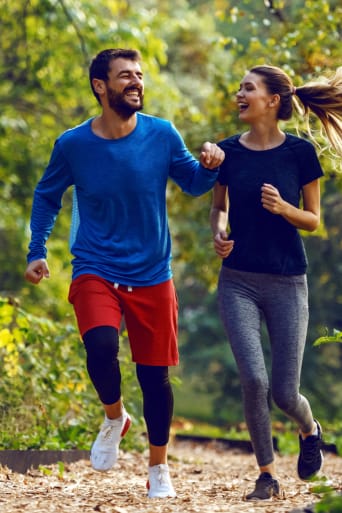 Idee sport: uomo e donna fanno jogging al parco. 